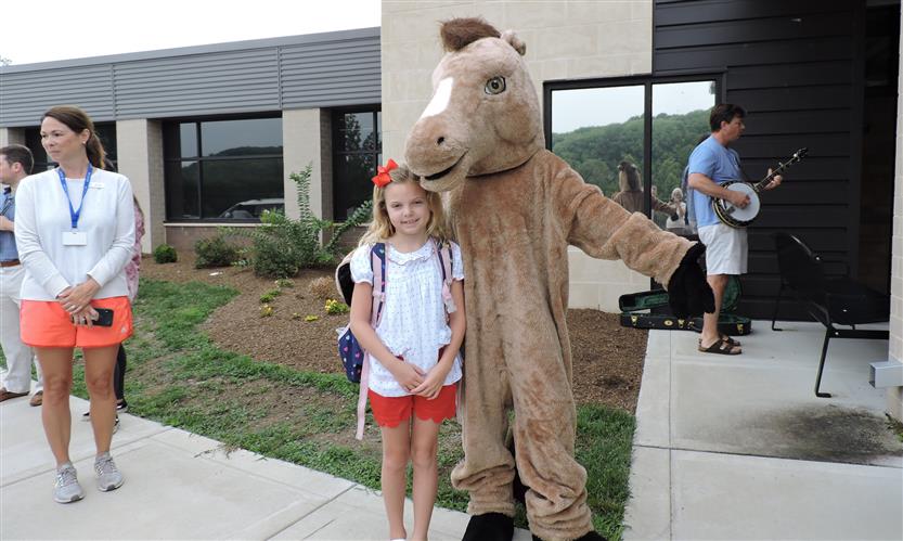 A student takes a photo with a horse mascot